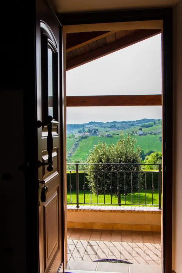 Porta aperta sulla terrazza con vista sulle colline marchigiane