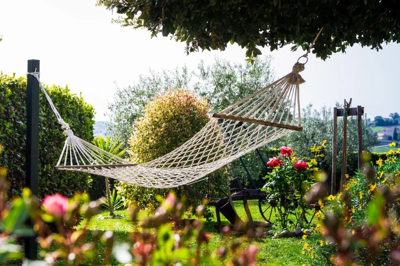 Amaca in giardino tra ulivi, rose e fiori