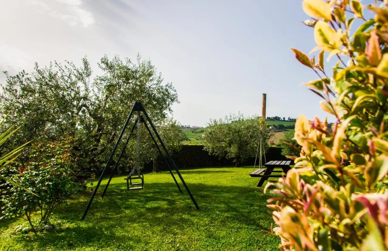 Giardino con altalena, ulivi e tavolo da picnic