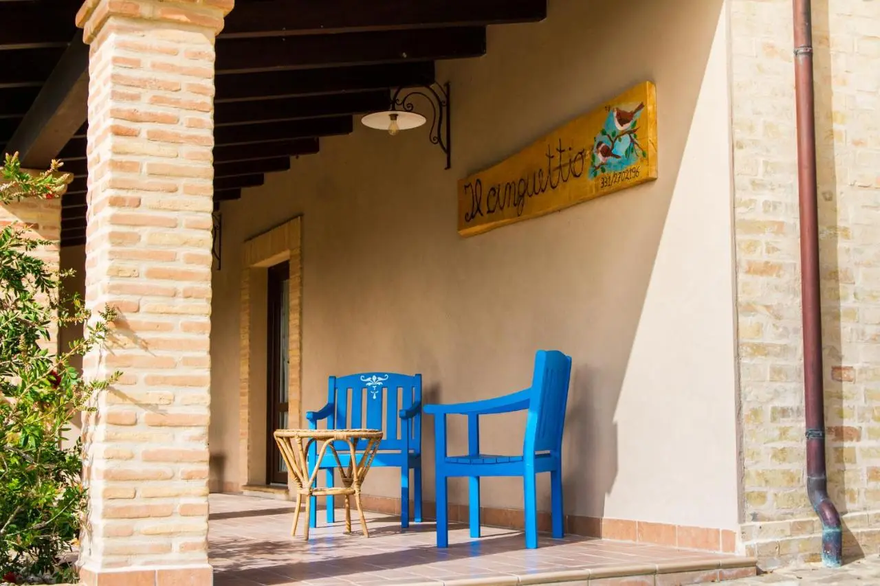 Portico con insegna Il Cinguettio e sedie blu