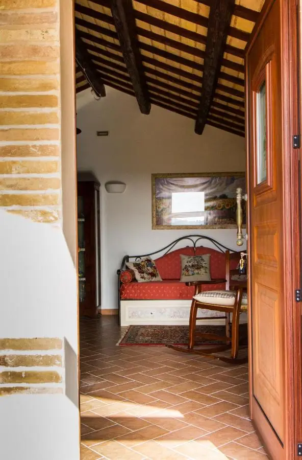 Ingresso al soggiorno con divano rosso e travi