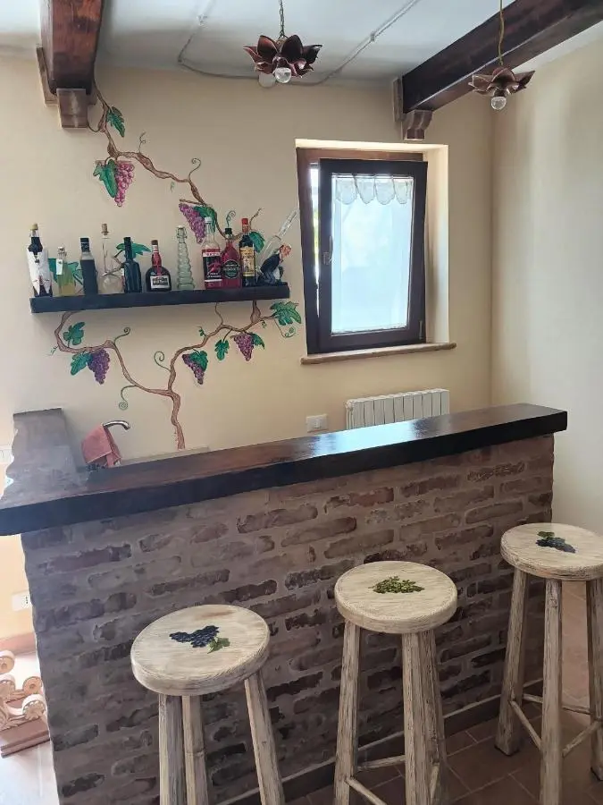 Angolo bar in mattoni con sgabelli e decorazioni a vite
