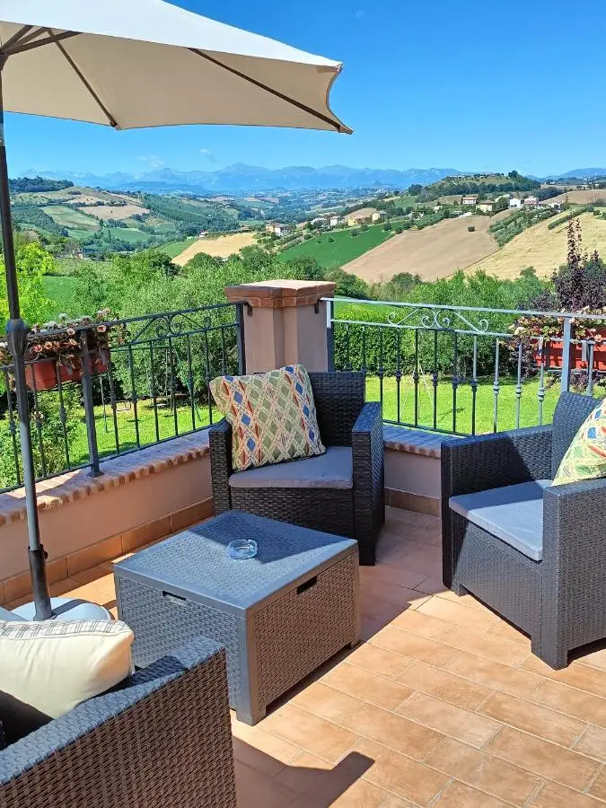 Salotto in terrazza con ombrellone e vista sui Sibillini