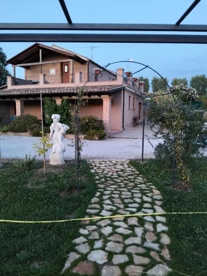 Villa al crepuscolo con statua e vialetto in pietra